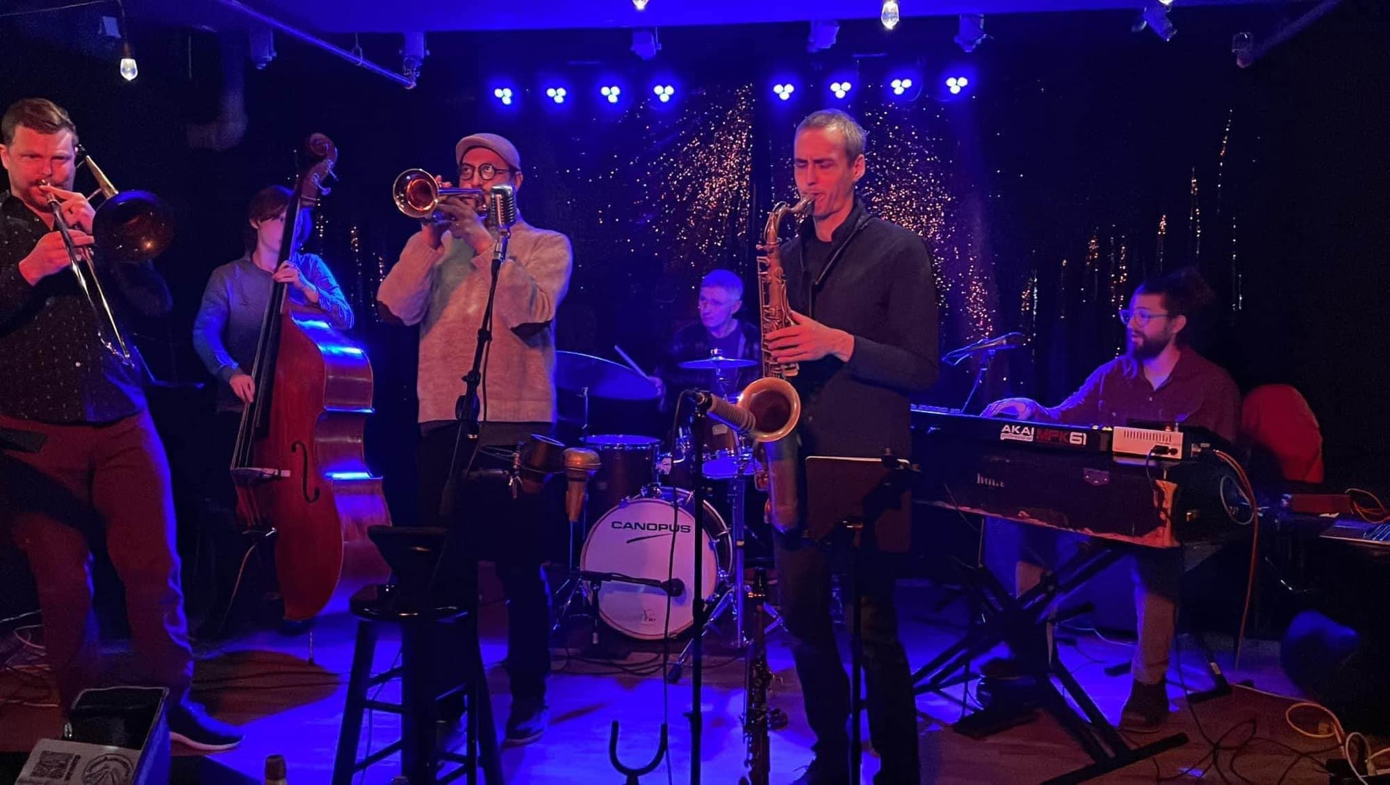 A jazz ensemble performing under blue stage lights