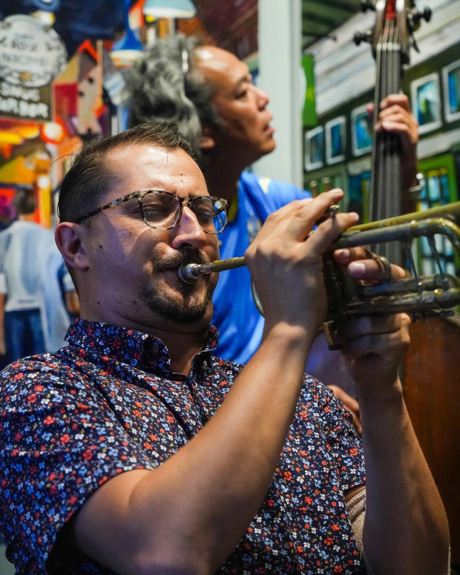 Close-up of Reid Poole playing trumpet with a bassist behind him